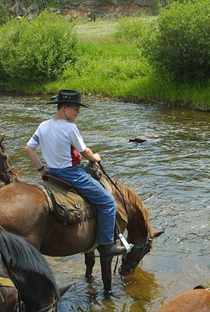 Taking a water break during a horseback riding vacation at Tarryall River Ranch