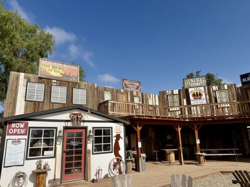 CaliforniaRanchCompanyCRCTrails640x480 False front Western town with a general store and blacksmith shop. CRC Trails by Horseback sign is below the General Store sign.